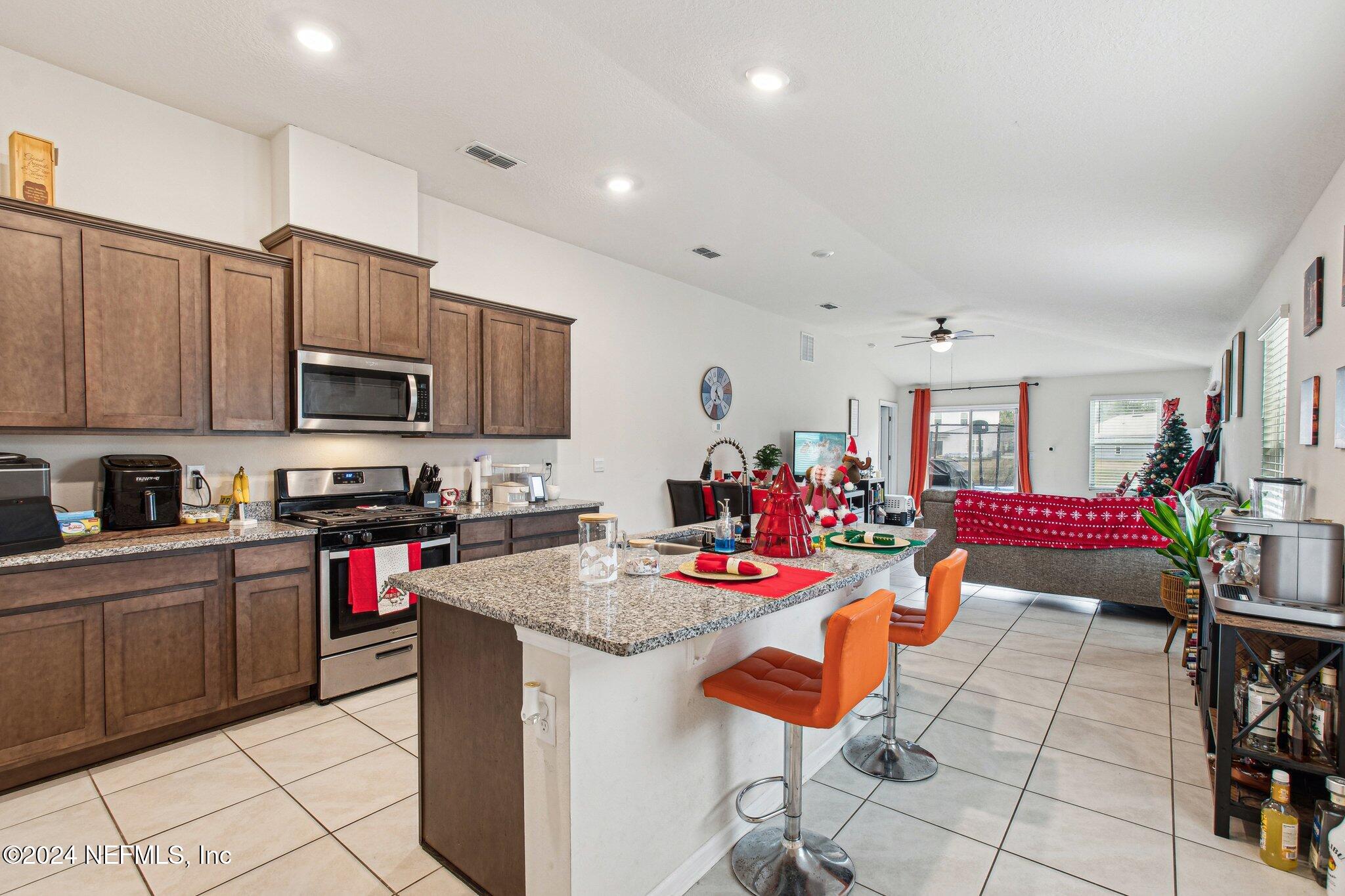 86253 Mainline Road Yulee, FL 32097 - Photo 13 of 39 a kitchen with stainless steel appliances kitchen island granite countertop a sink and cabinets