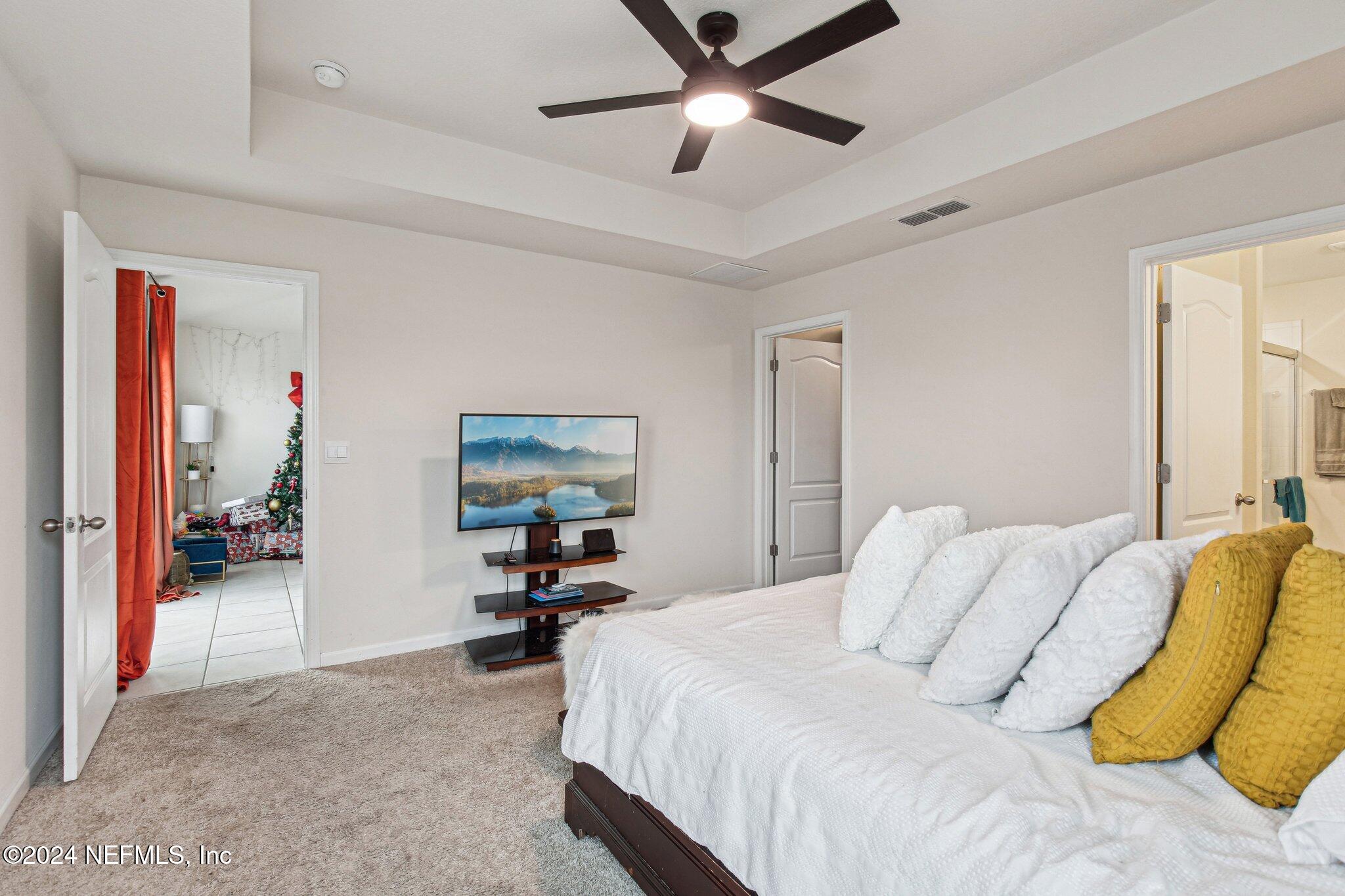 86253 Mainline Road Yulee, FL 32097 - Photo 22 of 39 a bedroom with a bed and a chandelier