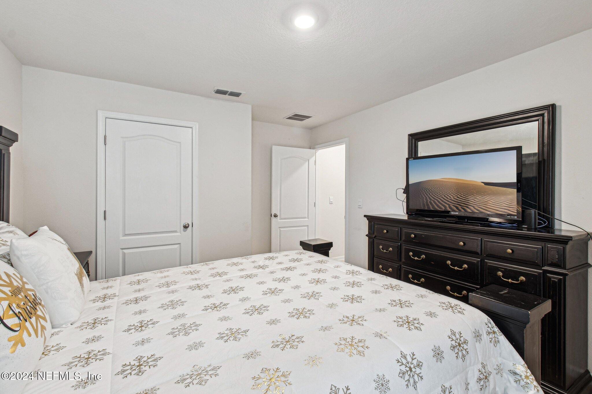 86253 Mainline Road Yulee, FL 32097 - Photo 31 of 39 a bedroom with a bed and a flat screen tv