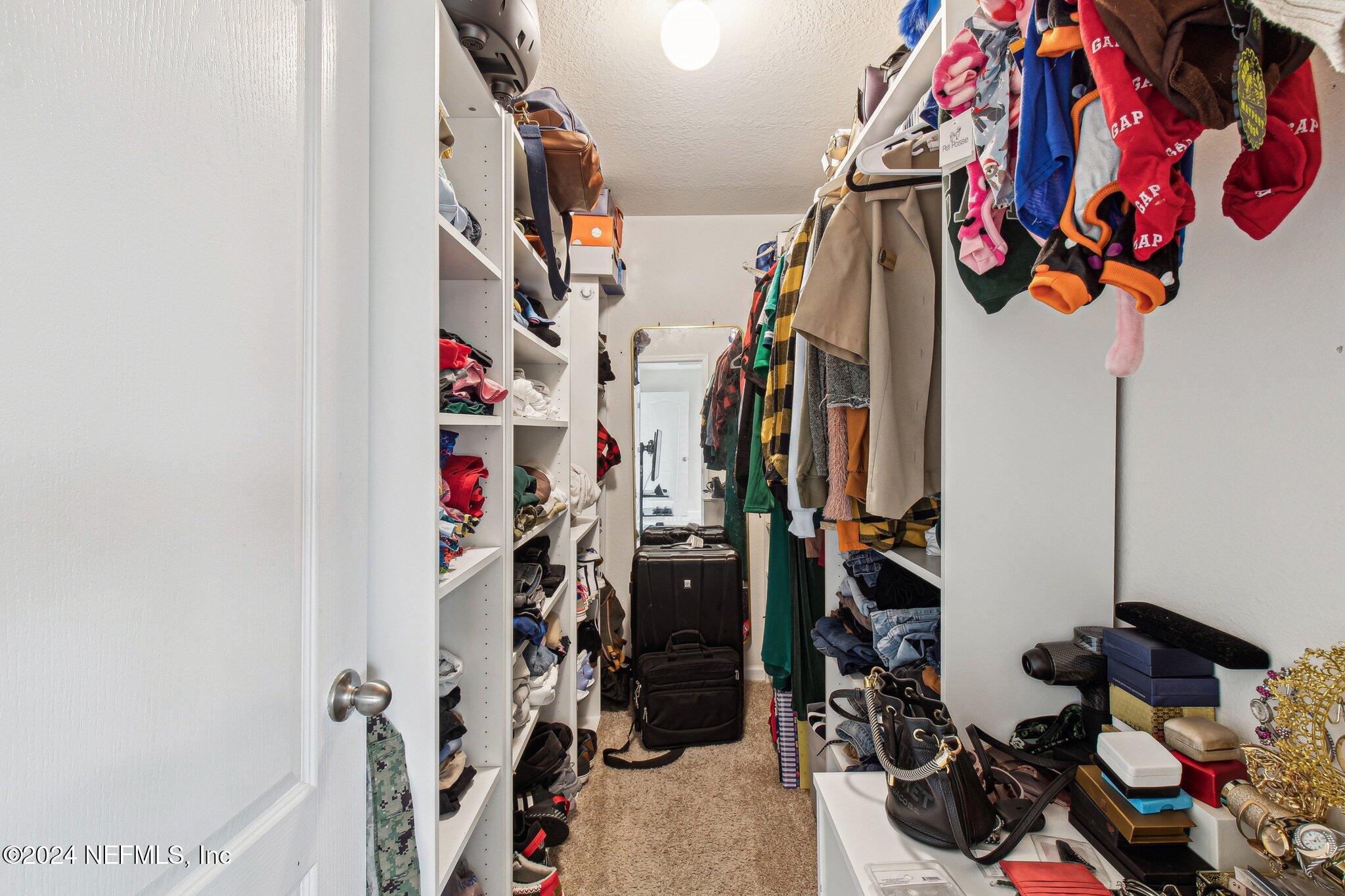 86253 Mainline Road Yulee, FL 32097 - Photo 34 of 39 a view of walk in closet with clothes
