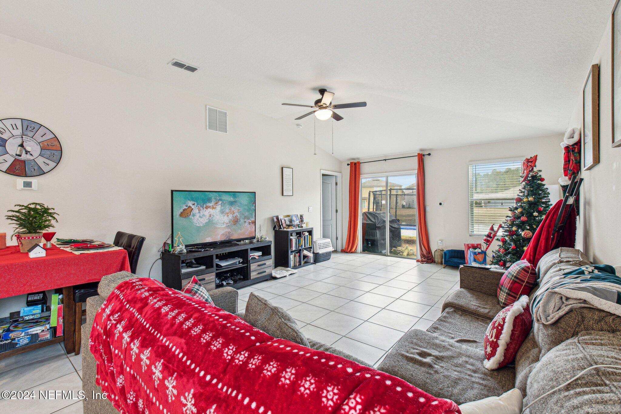 86253 Mainline Road Yulee, FL 32097 - Photo 8 of 39 a living room with furniture a flat screen tv and a large window