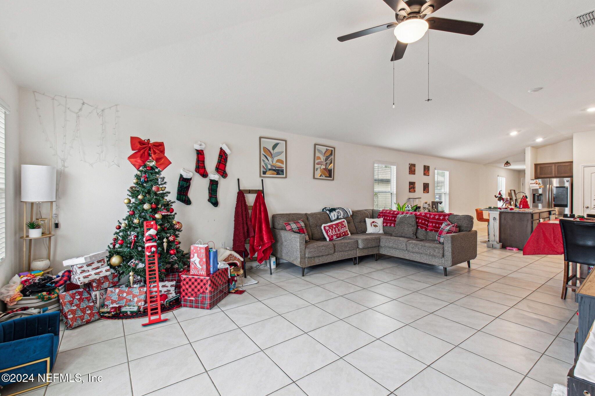 86253 Mainline Road Yulee, FL 32097 - Photo 9 of 39 a living room with lots of furniture and lots of potted plants