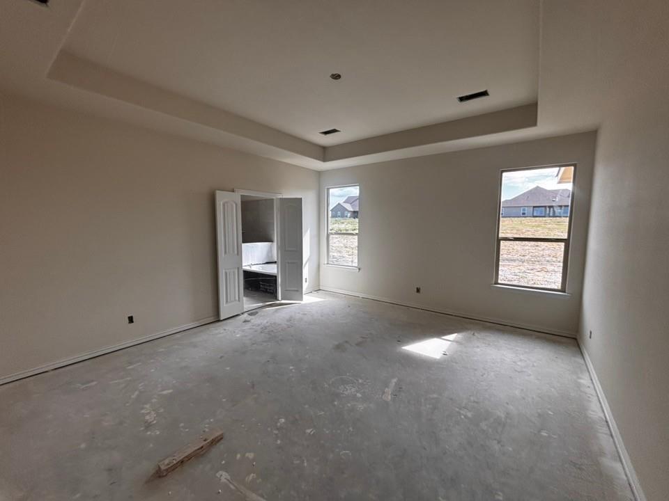 Smooth interior walls with a neutral paint finish, a single window with a white frame, and a concrete floor