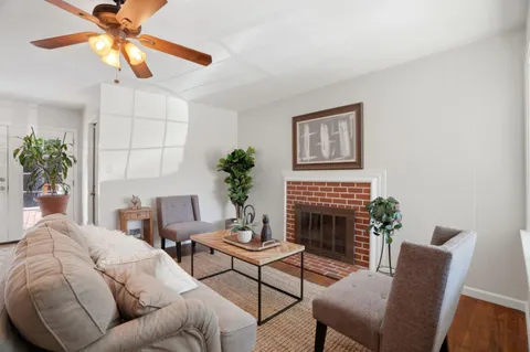 a living room with furniture fireplace and a potted plant