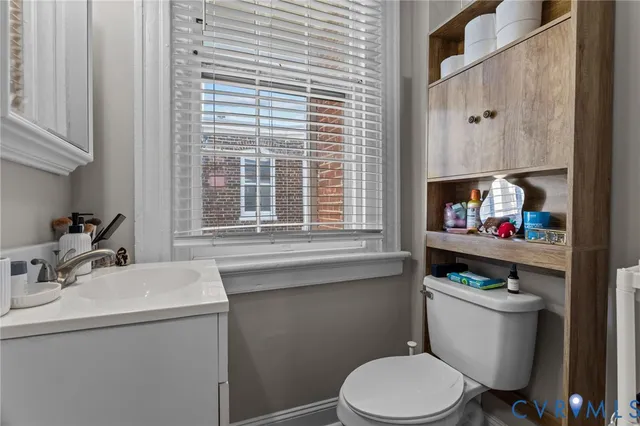 a bathroom with a sink a toilet and a window