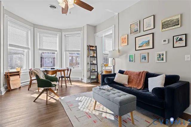a living room with furniture wooden floor and a large window