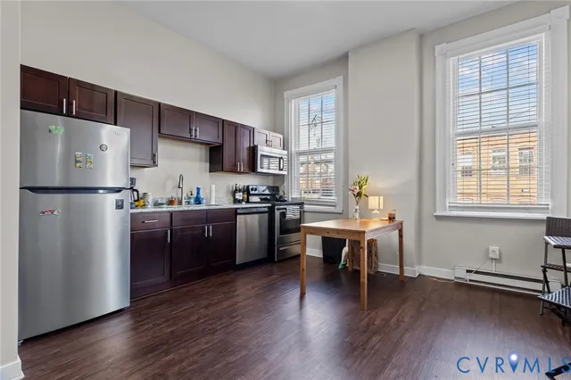 a kitchen with stainless steel appliances wooden floors and wooden cabinets
