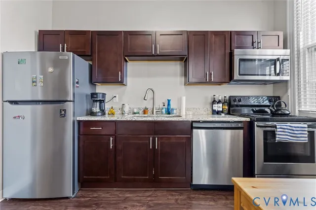 a kitchen with stainless steel appliances granite countertop a refrigerator and a sink