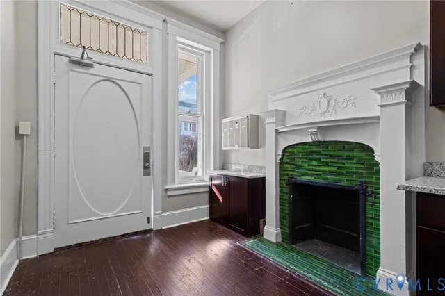 a view of front door with hallway and wooden floor
