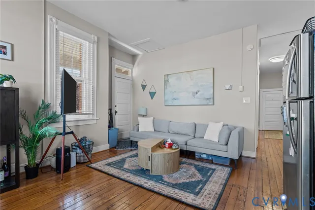 a living room with furniture and wooden floor