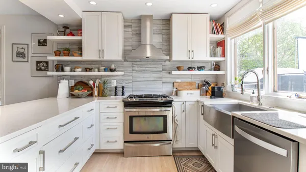 a kitchen with stainless steel appliances kitchen island granite countertop a stove a sink and a refrigerator