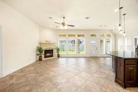 a view of an empty room with a fireplace and a window
