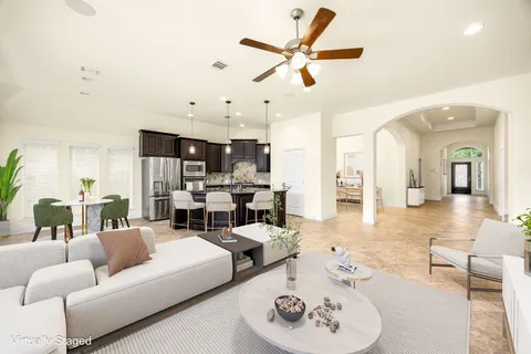 a living room with furniture kitchen view and a chandelier