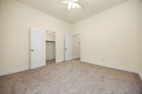 an empty room with a ceiling fan and a window