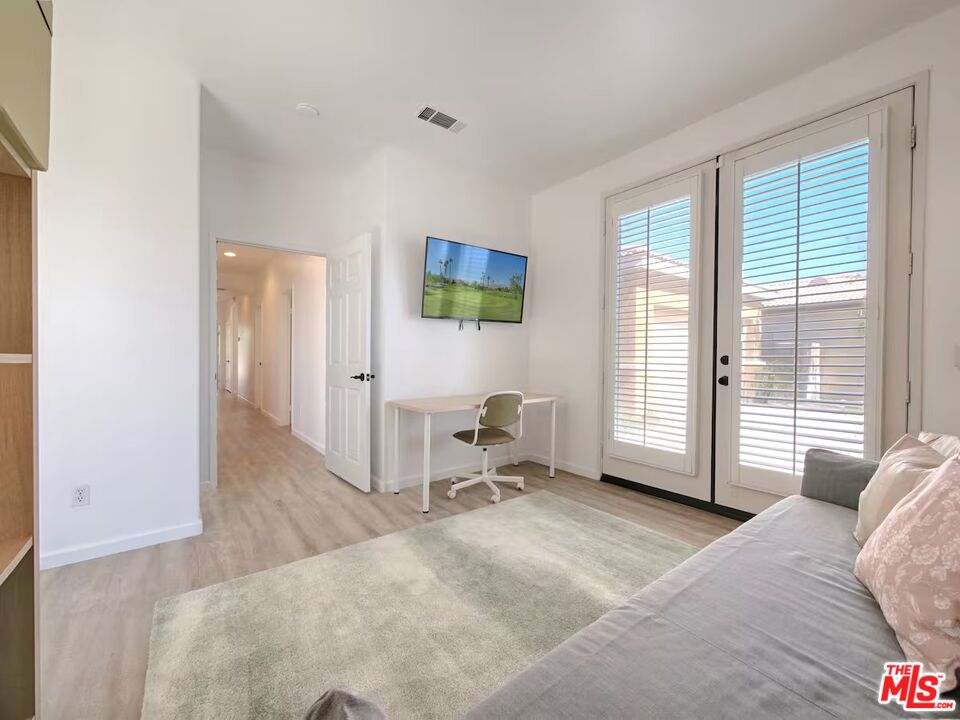 80718 Mountain Mesa Drive Indio, CA 92201 - Photo 18 of 43 a bedroom with a bed and large windows