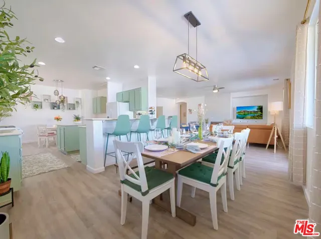 a dining room with furniture a chandelier and wooden floor