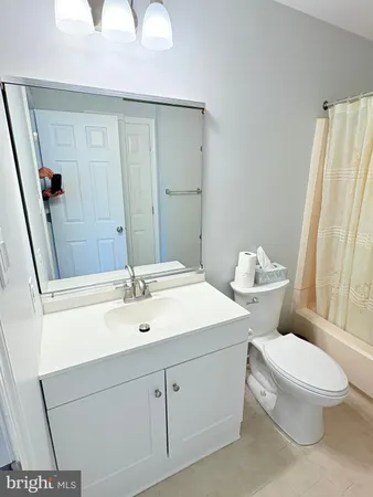 a bathroom with a sink a toilet a mirror and shower