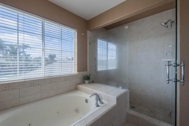 a bathroom with a bathtub and next to a window