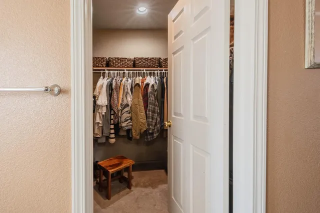 a view of walk in closet with clothes and shoes