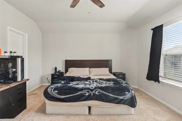 a bed sitting in a bedroom next to a window with a dresser