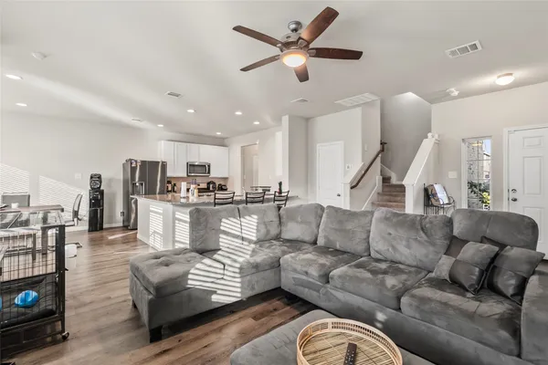 a living room with furniture kitchen view and a chandelier
