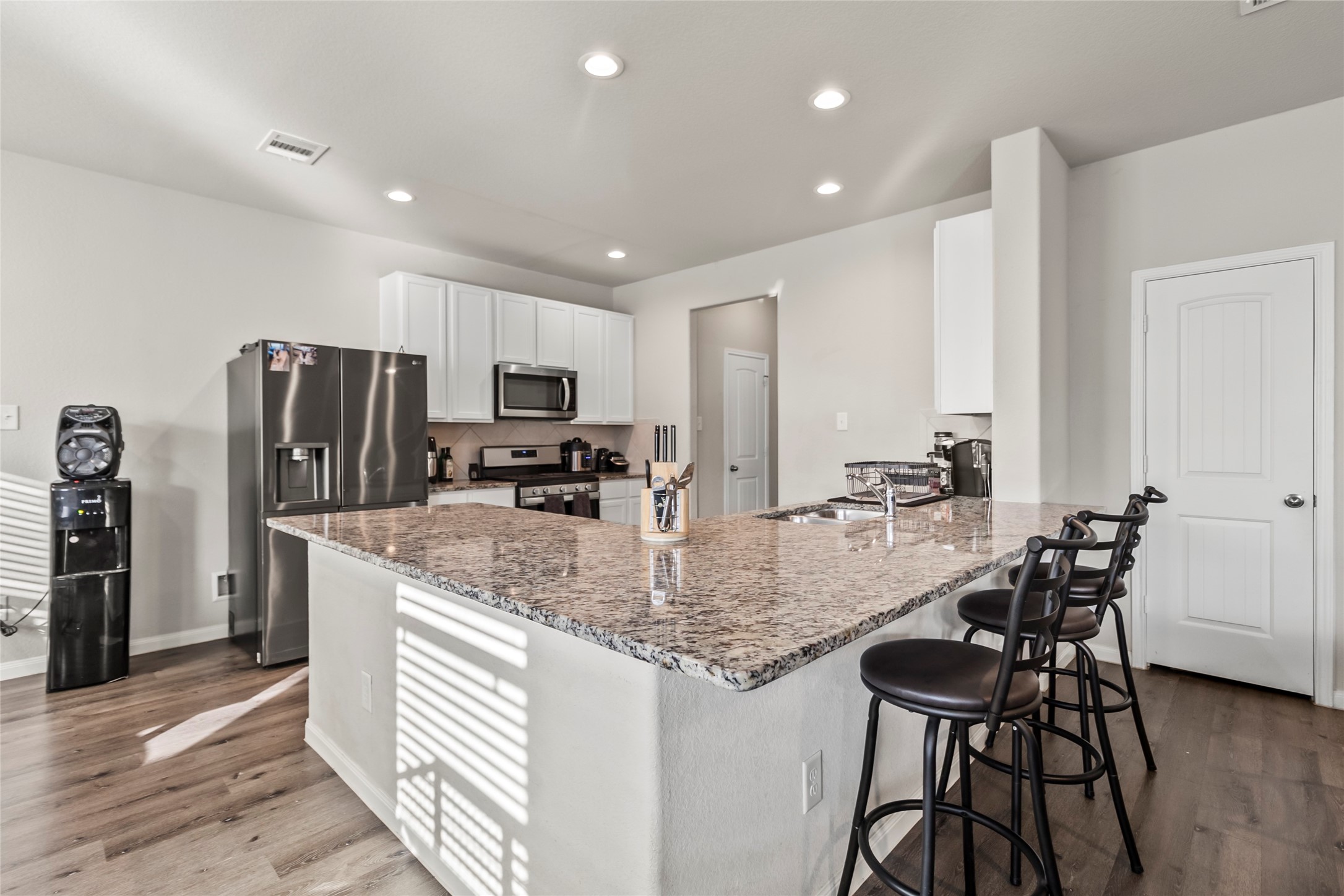 4831 Blue Jacaranda Way Spring, TX 77373 - Photo 7 of 24 a kitchen with stainless steel appliances granite countertop a table chairs and a refrigerator