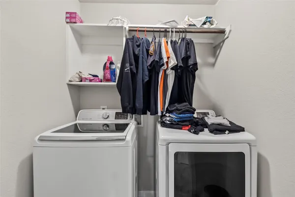 a view of walk in closet with clothes