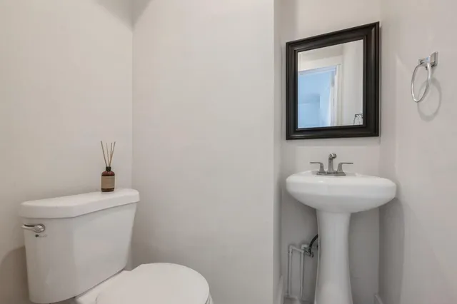 a bathroom with a toilet sink and mirror