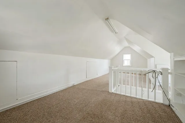 a view of staircase with white walls and fan