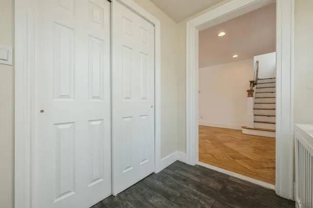 a view of an empty room with wooden floor