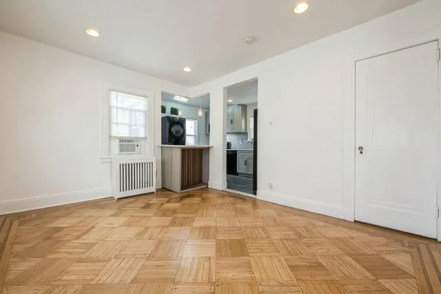a view of a kitchen with refrigerator and white cabinets