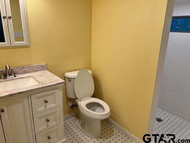 a bathroom with a granite countertop toilet and a sink