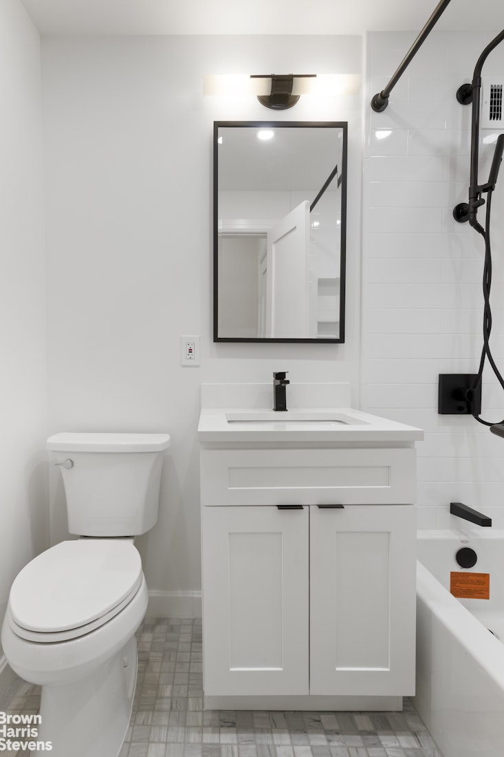 405 East 63rd Street, Unit 10H Manhattan, NY 10065 - Photo 4 of 9 a bathroom with a toilet sink and mirror