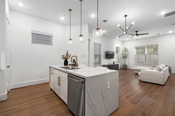a kitchen with kitchen island stainless steel appliances a stove a sink a center island a dining table and chairs