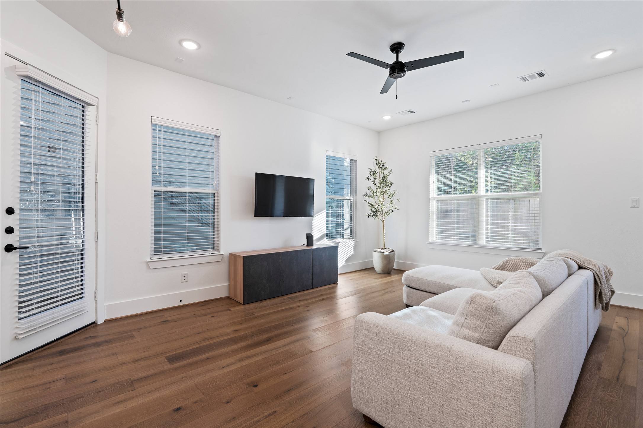 9011 Wellspring Drive Houston, TX 77080 - Photo 3 of 24 a living room with furniture floor to ceiling window hardwood floor and a flat screen tv