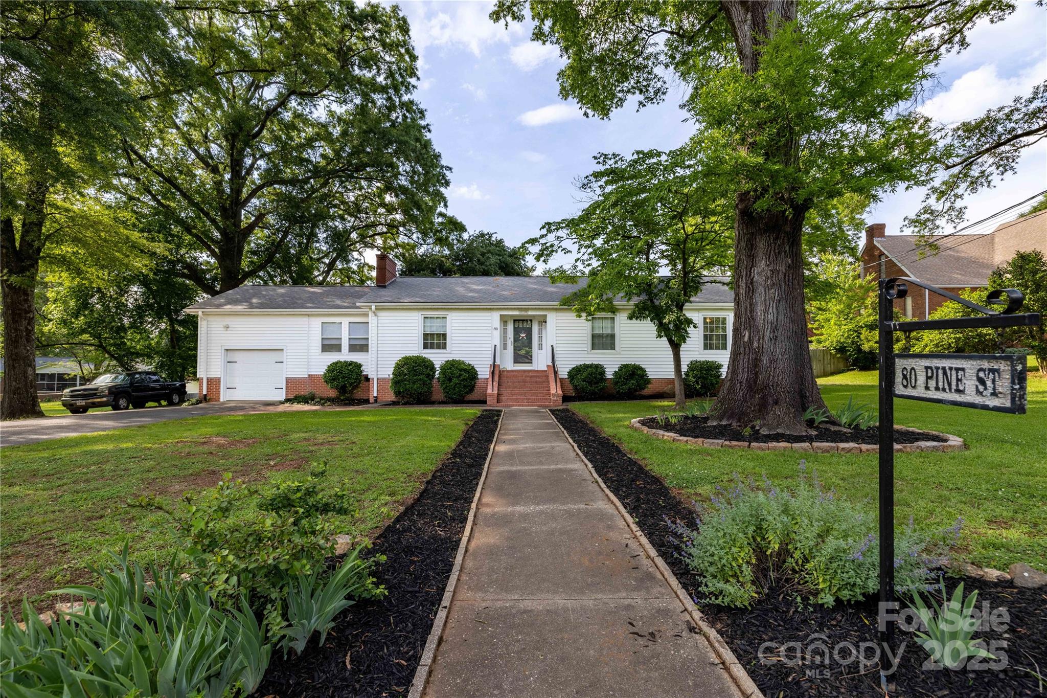 a front view of a house with a yard and potted plants