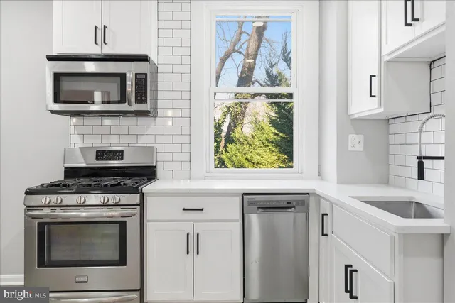 a kitchen with granite countertop a stove top oven microwave and cabinets
