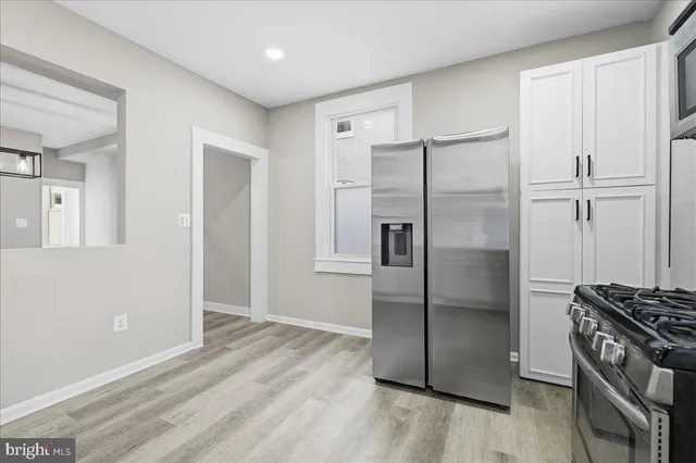 a kitchen with granite countertop a refrigerator and a stove top oven