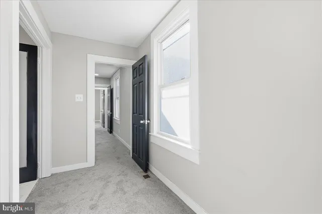 a view of an empty room with closet and a window