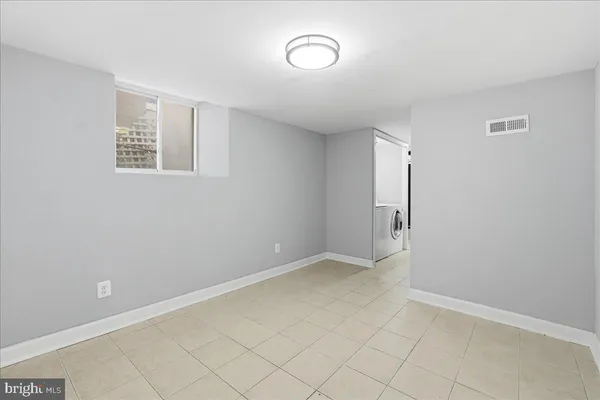 an empty room with a cabinet and mirror