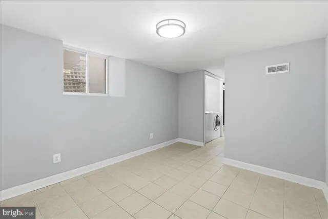 an empty room with a cabinet and mirror