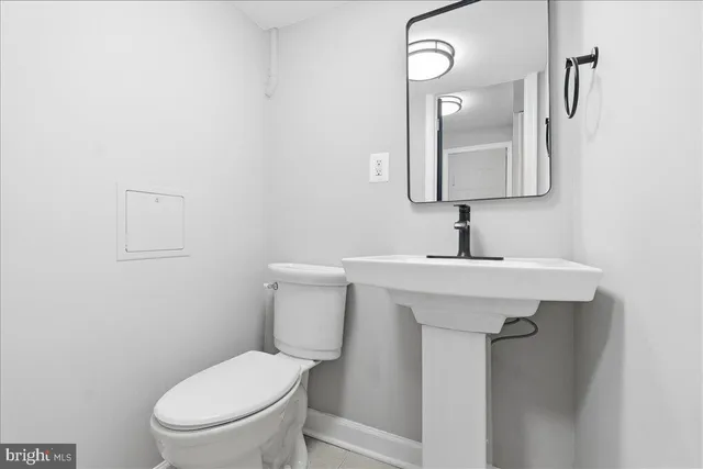 a bathroom with a toilet sink and mirror