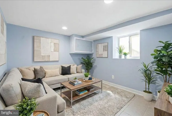 a living room with furniture plant and a window