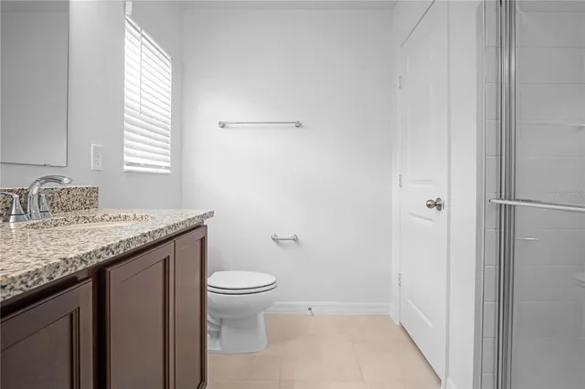 a bathroom with a granite countertop sink toilet and a mirror