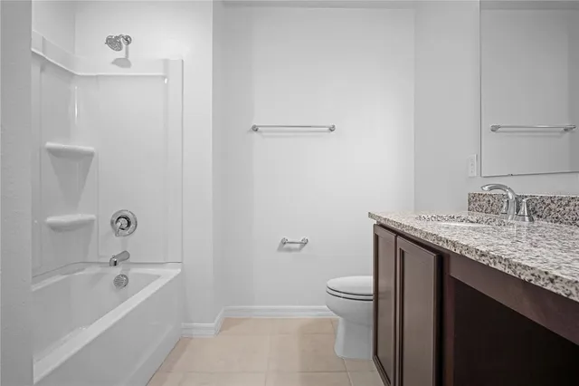 a bathroom with a granite countertop sink a toilet and shower
