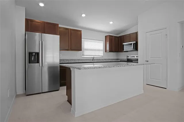 a kitchen with stainless steel appliances a refrigerator sink and microwave