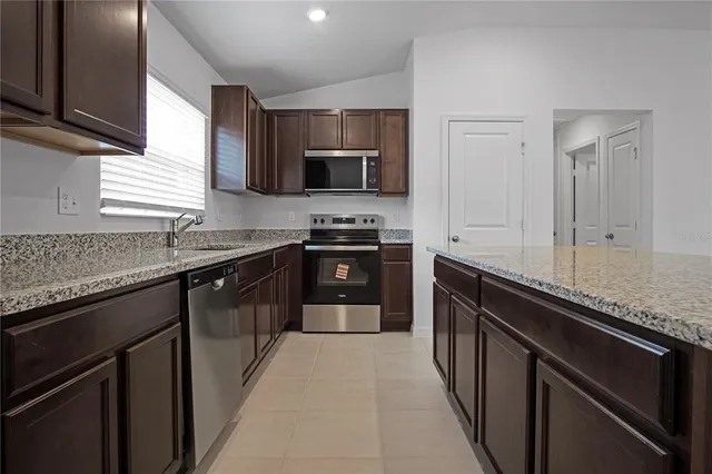 a kitchen with stainless steel appliances granite countertop a sink stove and cabinets