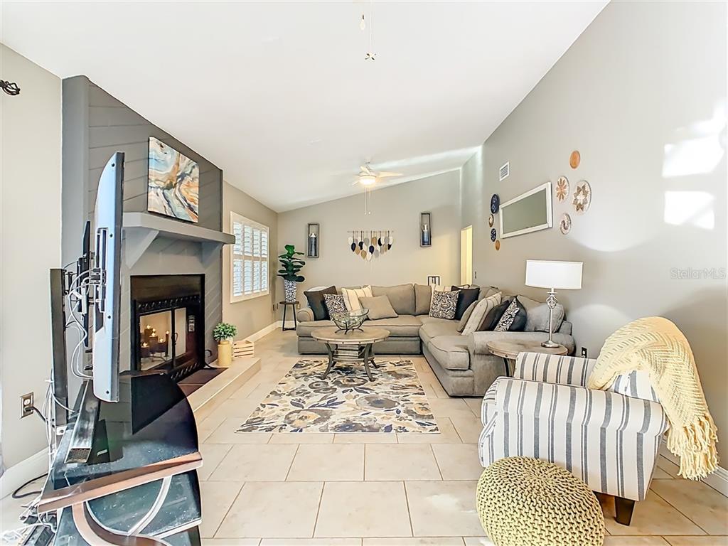 2901 Plantation Road Winter Haven, FL 33884 - Photo 15 of 30 a living room with furniture a fireplace and a flat screen tv
