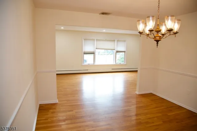 a view of a room with wooden floor and chandelier