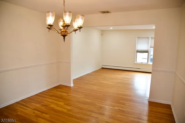 a view of a room with wooden floor and chandelier